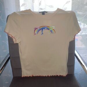 Cream shirt with orange ruffles. Rainbow and dolphins on front.